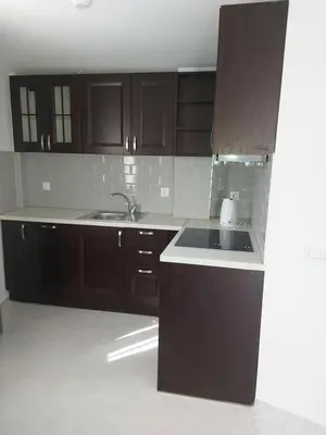 a kitchen with wooden cabinets and a sink at Мезонет Пасажио in Sandanski