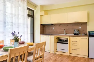 a kitchen with a wooden table and a dining room at Bendida Park in Velingrad