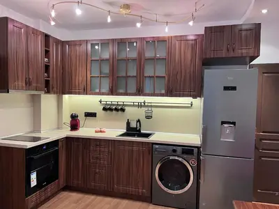 a kitchen with wooden cabinets and a washer and dryer at Dalv Residence - SPA Fairy Tale in old Sofia in Sofia