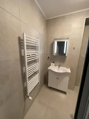 a white bathroom with a sink and a mirror at Movie flats in Sofia