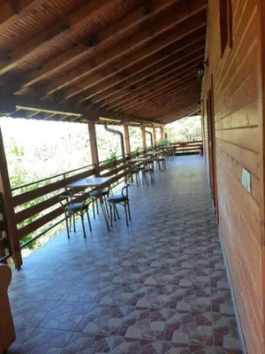 a porch with tables and chairs on a building at Райчевата къща - Кюстендил in Kyustendil