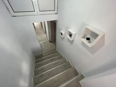 a staircase with white walls and a white stair case at Апартамент Панорама Рози in Sandanski