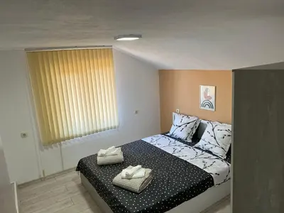 a bedroom with a bed with two towels on it at Апартамент Панорама Рози in Sandanski