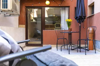 a patio with a table and chairs and an umbrella at Peaceful Riverside Studio with private Garden Center Parking in Plovdiv