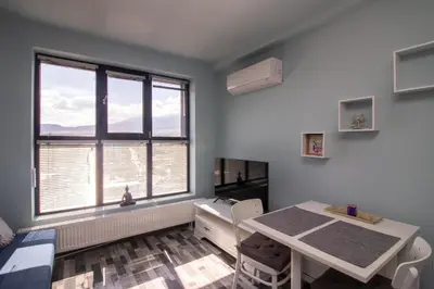 a dining room with a table and a table and chairs at Mountain View Apartment 1 + Parking in Sofia
