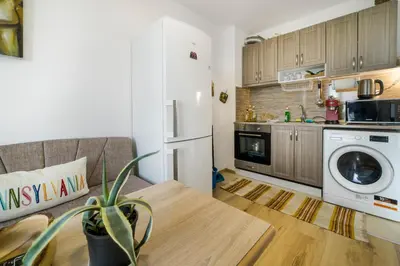 a kitchen with a refrigerator and a table in a room at City View Apartment + Parking in Sofia