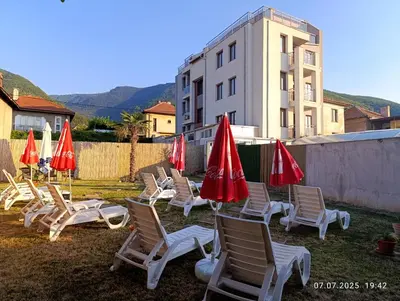 a group of chairs and umbrellas in a yard at ENIS Hotel със закрит и отоплен минерален басейн in Sapareva Banya