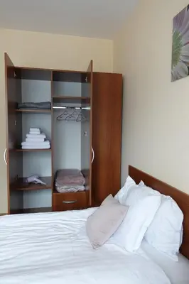 a bedroom with a white bed with a wooden headboard at GO GO Holiday in Borovets