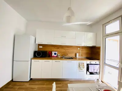 a kitchen with white cabinets and a white refrigerator at City Center 2-bedroom cosy apartment in Plovdiv