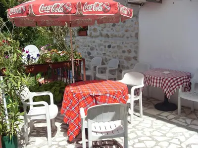 a patio with a table and chairs and an umbrella at Guest House Rimski Most in Melnik