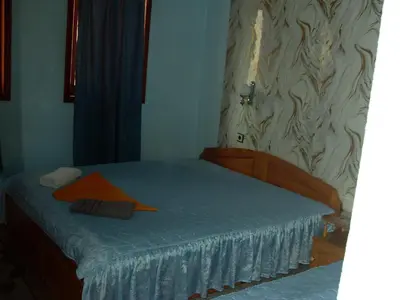 a small bedroom with a bed with a blue sheet at Guest House Rimski Most in Melnik