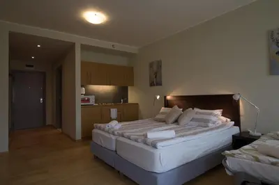 a bedroom with a large bed and a kitchen at Euphoria Club and Resort Rental in Bŭrduche