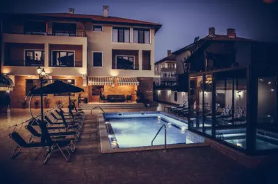 a swimming pool in front of a building at Слънчевите Къщи in Banya
