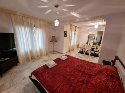 a bedroom with a red bed and a living room at Tsar Simeon, 2 bedroom, living room and fireplace in Sofia