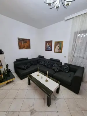 a living room with a black couch and a table at Tsar Simeon, 2 bedroom, living room and fireplace in Sofia