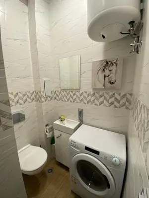 a bathroom with a toilet and a washing machine at La Luna - High-end 2BD Flat in the TOP centre by Flat Mаnager in Sofia