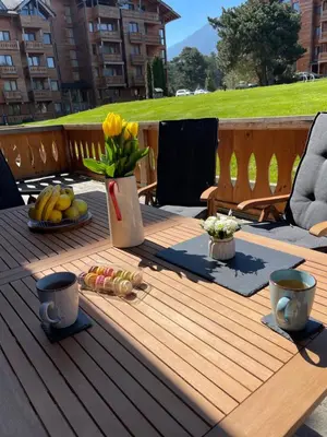 a wooden table with food and flowers on a deck at Allure in Pirin Golf in Razlog