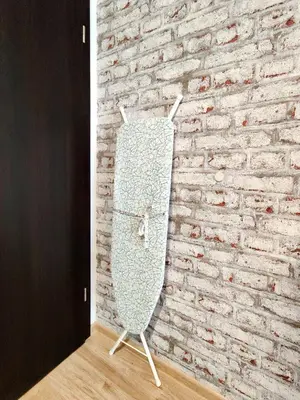 a surfboard on a stand in front of a brick wall at Cozy Studio near the Historical Heart of Sofia by Flat Mаnager in Sofia