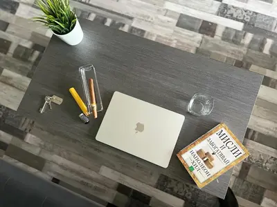a table with a laptop computer and a book on it at Flower house 2 in Sofia