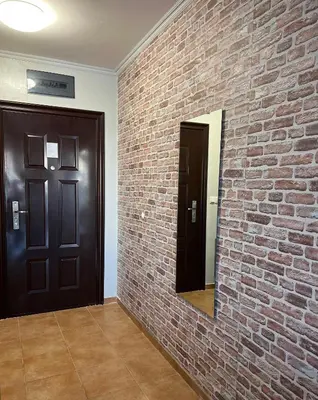 a brick wall with a mirror and two doors at Flower house 2 in Sofia