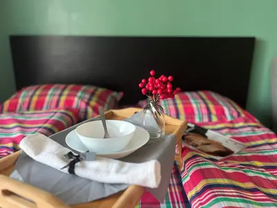 two beds with a tray with a bowl and a bowl at Flower house 2 in Sofia