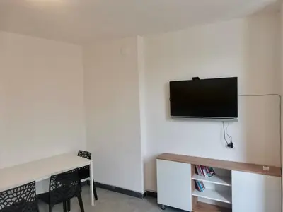 a room with a desk and a television on a wall at The rainbow 3 in Sofia