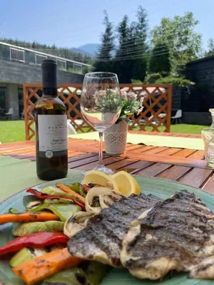 a plate of food and a glass of wine at Saint George Palace Deluxe Collection in Bansko