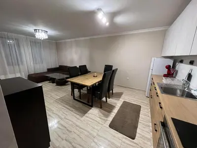 a kitchen and living room with a table and a couch at Апартамен в Манастира 3 in Smolyan