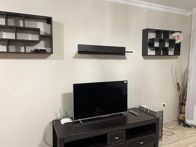a flat screen tv sitting on top of a black entertainment center at Апартамен в Манастира 3 in Smolyan