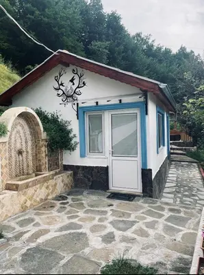 a small house with a door and a stone patio at Cozy Home in Ardino in Ardino