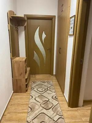 a hallway with a door with a rug in front of it at Апартамент за гости in Devin