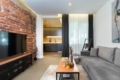 a living room with a couch and a brick wall at Lozenets Modern Apartment Tranquil & Central in Sofia