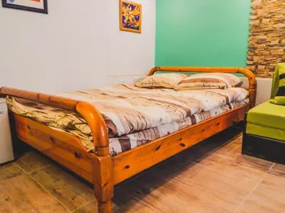 a bed with a wooden frame in a room at Top Center Studio 1 in Sofia