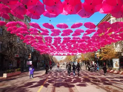 a group of pink umbrellas hanging over a street at Top Center Apartment 2 in Sofia