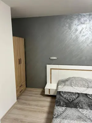 a bedroom with a bed and a gray wall at Комплекс Замъка 2 ап 301 in Pamporovo