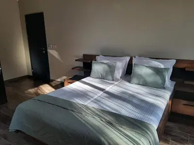 a bedroom with a large bed with white sheets and pillows at Вила Bora Vista 1 in Tsigov Chark