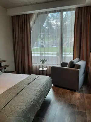 a bedroom with a bed and a couch and a large window at Вила Bora Vista 1 in Tsigov Chark