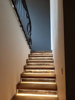 a stairway with a metal railing and stairs with a blue wall at Вила Bora Vista 1 in Tsigov Chark
