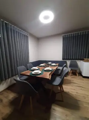 a dining room with a wooden table and chairs at Вила Bora Vista 2 in Tsigov Chark