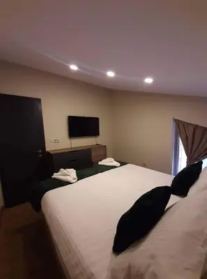 a bedroom with two beds and a flat screen tv at Вила Bora Vista 2 in Tsigov Chark