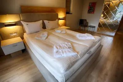 a large bed with white sheets and towels on it at MOUNTAIN HILL LUXURY VILLA in Madzhare