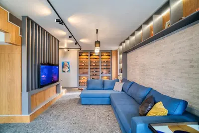a living room with a blue couch and a tv at MOUNTAIN HILL LUXURY VILLA in Madzhare