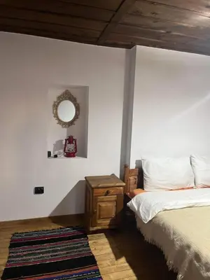 a bedroom with a bed and a mirror on the wall at Къща за гости Близнаците in Leshten