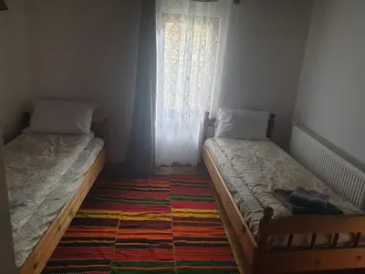 two twin beds in a room with a window at Къща за гости Близнаците in Leshten