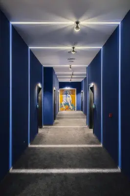 a hallway with blue walls and a painting on the wall at Art Magus Hotel in Sofia