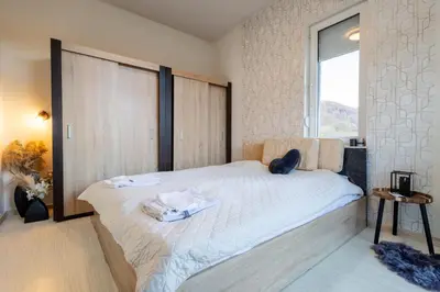 a cat sitting on a bed in a bedroom at Вила Ибър село Радуил in Raduil