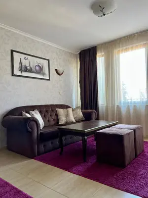 a living room with a couch and a coffee table at Гранд Манастира частен апартамент in Pamporovo