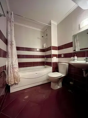 a bathroom with a tub and a toilet and a sink at Гранд Манастира частен апартамент in Pamporovo