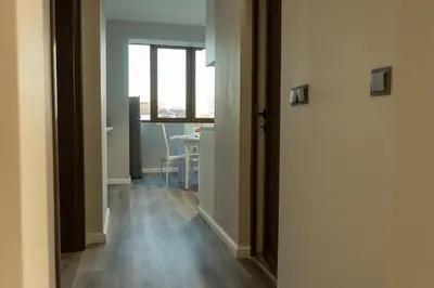 a hallway with a room with a table and a door at Jasmine Central Apartment in Sofia