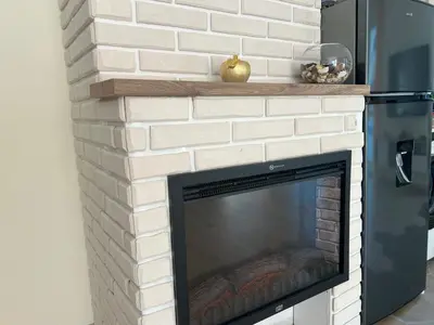 a white brick fireplace with a wood mantel at Barceló Apartment Velingrad in Velingrad